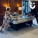 Air Hockey Table Hire at a daytime wedding with a Husband and wife dressed in their wedding best playing