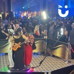 a group of 4 take their place on the 360 Photo Booth at an indoor awards event surrounded by a crowd