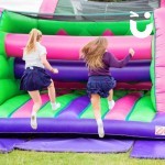 Assault Course Main Section Inflatable with 2 school girls leaping onto the course