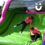 Assault Course Main Section Inflatable with 2 womean sliding down end of course during a corporate team build event