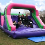 Assault Course Main Section Inflatable with 5 womean sliding down end of course during a corporate team build event