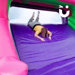 Assault Course Cargo Net Hire with a lady sliding down inflatable head first on her front