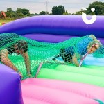 Assault Course Scramble Net Inflatable hire at a school event with 2 teachers crawling through net