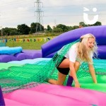 Assault Course Scramble Net hire at a school event with a student kneeling on inflatable