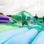 Children playing on our Assault Course Scramble Net Inflatable Hire during a fun day event