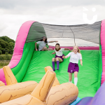 A group of girls coming down our inflatable Assault course slide and about to test the Assault Course Balance Run Hire