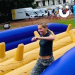 Assault Course Balance Run Outside on grass at corporate fun day with woman running on it smiling