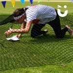 Man with headband climbing through the Assault Course Scramble Net