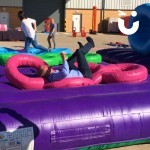 Assault Course Inflatable Tyres at a corporate ffice event with a man fallen over on his back laughing