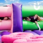 Assault Course Mangles Hire at a school event with 2 young girls climbing through inflatable