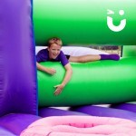 Assault Course Mangles Hire at a school event with a young boy climbing through inflatable
