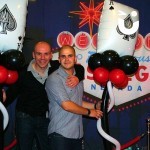 Las Vegas Backdrop with 2 men holding balloons celebrating at a themed party