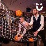 Basketball Hire 5 at a corporate staff party indoors with 2 men having fun on it