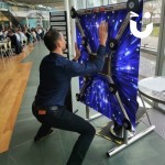 Batak Hire 6 set up in a corporate building canteen with a man having a go and people eating in the background