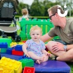 Big Rubber Lego 1 hire at a family fun day with a beautiful baby sat on the lego mat with her dad playing