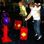 Two young boys competing to be the first to blow up their balloon with the Boom Balloon Blasters Hire