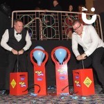 Boom Balloon Blasters Hire at an indoor corporate black tie dinner event pumping the detonators to pop their balloons