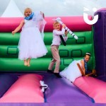 Adult Castle at a wedding with 2 little bridesmaids and a little page boy having fun bouncing with novelty prizes