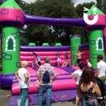 Large Event Castle 2 at a corporate family fun day with lots of children having fun and parents watching on