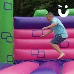 adult man playing on the bouncy castle hire