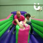 Bungee Run Hire inside a sports hall with a mother and adult son going head to head to win