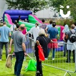 Bungee Run Hire at a comunity event with a crowd of onlookers and people waiting for a turn