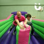 Two young men both reaching the end of the bungee run at the same time