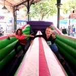 Two young girls racing against each other at an outdoor community event