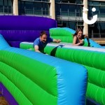 A young couple racing on our Bungee Run Hire at a university event