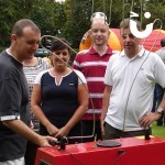 A gorup of guest spectate a contestant on the Hand Buzz wire Hire during a fun day event