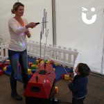 A child watches in amazement as a women guides the wand through the Hand Buzz wire Hire