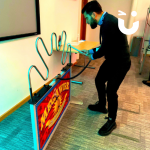 Man playing Mega Buzz Wire indoors at a corporate event