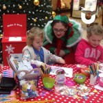 One of Santas elves helping children at the Christmas crafts (Main Tile)