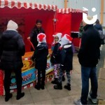 Elf On The Shelf Side Stall Hire at a festive family day with children winning prizes and their parents watching on