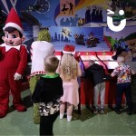 Christmas Funfair 7 Roll a Ball Racing Reindeer being used by 3 children and an adult dressd at the grinch at a festive party
