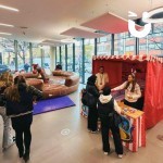Penguin Skittles Stall set up in an office atrium being played on by 2 colleagues with a rodeo reindeer in the background