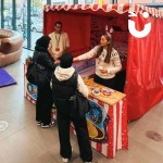 Penguin Skittles Stall set up in an office atrium with 2 colleagues aiming to win a prize