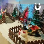 A festive set up showing Christmas props such as reindeer, a snowman, a sleigh, throne and trees
