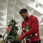 Christmas Tree Buzz Wire set on a table with a man concentrating hard on getting the wand around the wire without it buzzing