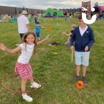 Circus Skills Workshop Hire with a young brother and sister learning to hua hoop and use a diablo at a corporate fun day