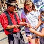 A Cow boy showing a couple of young girls how to Diabalo