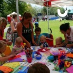 Craft Workshop at a family fun day set up under a gazebo with children and their mothers creating colourful artwork