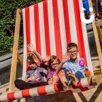 Three young children enjoying the Giant Deckchair Hire