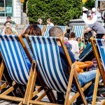 People enjoying a relaxing sit down on our blue and white Deckchair Hire