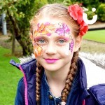 Young girl painted with pink and orange flowers from the Face Painting Children Hire