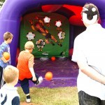 Guests watch as a young boy plays on the Football Shoot Out Inflatable Hire