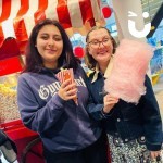 Candy Floss and Popcorn on the same cart with 2 young women enjoying their treats