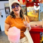 Candy Floss and Popcorn on the same cart with a lady thoroughly enjoying herself
