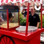 One of the Fun Experts with the Candy Floss Popcorn On The Same Cart during an outdoor fun day
