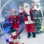 Christmas Giant Snow Globe Hire 1 with a man  and woman dressed as Mr and Mrs Clause